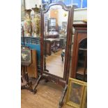 A 1920s mahogany cheval mirror, the shaped bevelled plate on carved scroll feet, 167.5cm high