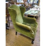 A George III style green upholstered wing armchair with acanthus carved cabriole legs and ball and