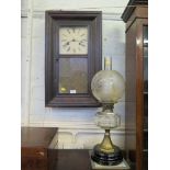 An American wall clock, striking on a gong, and a glass and brass oil lamp (2)