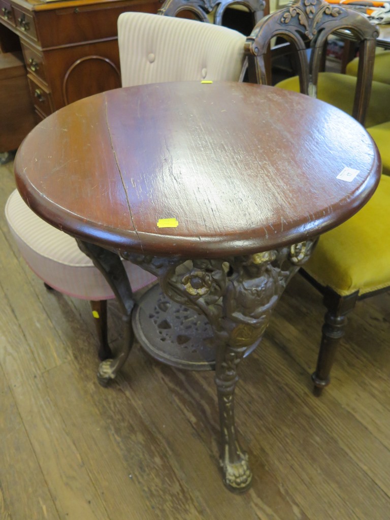 An early 20th century cast iron table, cast with Britannia figures on three legs with lion paw feet,