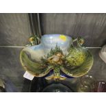 A Ginori Italian Maiolica trefoil pedestal dish, depicting cupid, with serpent handles, underglaze