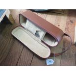 A Tan leather travel single wine bottle case, interior padded suede with pocket including