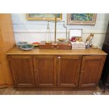 An oak side cupboard, with two pairs of panelled doors on a plinth base 186cm wide 92cm high