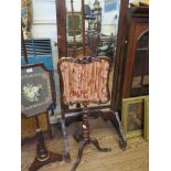 An early Victorian rosewood pole screen, the foliate carved screen on a baluster turned stem and