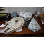 Two Star Wars Millennium Falcon toy models, a battle cruiser and two other Star Wars related toys