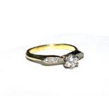 A single stone diamond ring with diamond set shoulders set in yellow gold