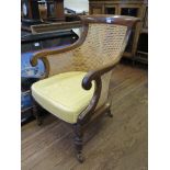 A Regency mahogany Begere chair, the canework back and arms on turned legs and castors