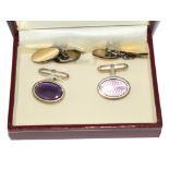 Two pairs of cufflinks, 9 carat gold on silver and the other silver with purple enamel