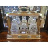 An oak and brass mounted three bottle tantalus 38cm wide