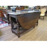 An 18th century oak gateleg table, the oval top on bobbin turned legs joined by stretchers, with pad