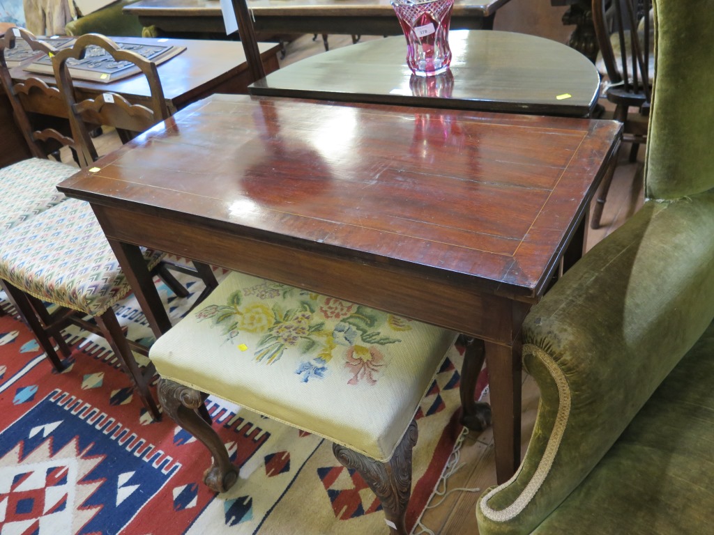 A cross banded mahogany foldover tea table, boxwood and ebony strung frieze on square section