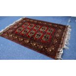 A MID TO LATE 20TH CENTURY MIDDLE EASTERN STYLE RED GROUND RUG with repeating geometric patterns and