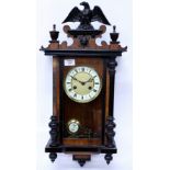 AN ANTIQUE WALNUT CASED VIENNA TYPE WALL CLOCK with eagle crest, 30cm wide x 66cm high