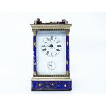 A 20TH CENTURY CARRIAGE CLOCK with brass and champleve enamel decorated case, standing on stepped