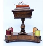 A VICTORIAN ROSEWOOD PIN CUSHION AND THREAD STAND with sarcophagus shaped pin cushion on a