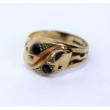 A 9 CARAT GOLD RED STONE SET SNAKES HEAD CROSSOVER RING