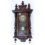 AN OLD WALNUT CASED VIENNA REGULATOR TYPE WALL CLOCK with turned finials, 38cm wide x