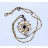 AN EARLY 20TH CENTURY YELLOW METAL PENDANT of pierced foliate form, set with a central amethyst