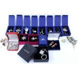 A COLLECTION OF COSTUME JEWELLERY to include a silver charm bracelet, brooches, Swarovski