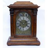 AN OAK CASED TABLE CLOCK with pilaster columns to either side with engraved brass dial, subsidiary