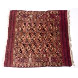 AN ANTIQUE TEKKE BOKHARA RUG with a red ground and geometric decoration 94cm x 101cm