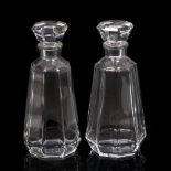 A PAIR OF BACCARAT CRYSTAL DECANTERS of tapering form with facet cut decoration, matching stoppers