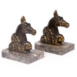 A PAIR OF BRONZED SPELTER ART DECO STYLE HORSES HEAD ORNAMENTS mounted on marbled bases, each with a