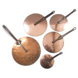 FIVE GRADUATED COPPER SAUCEPAN LIDS with iron strap handles, the largest 60cm overall (5)