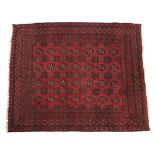 A LATE 20TH CENTURY MIDDLE EASTERN RED GROUND RUG with a banded border and geometric decoration