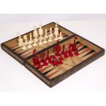 A LATE 19TH / EARLY 20TH CENTURY MATCHED STAINED BONE CHESS SET, the folding board in the form of