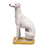 A CONTEMPORARY ITALIAN POTTERY SCULPTURE in the form of a greyhound seated on a cushion, decorated