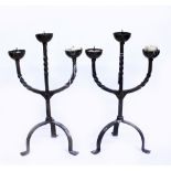 A PAIR OF WROUGHT IRON THREE LIGHT CANDELABRA on tripod bases, each 46cm high