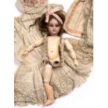 A FRENCH BISQUE HEADED PORCELAIN DOLL by Nadaud with paper label stuck to her back, the doll missing