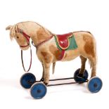 A MID 20TH CENTURY STEIFF HORSE on wheels, with button in ear, 55cm high