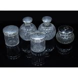 A GROUP OF FOUR MATCHING CUT GLASS SILVER TOPPED DRESSING TABLE JARS and bottles, marks for