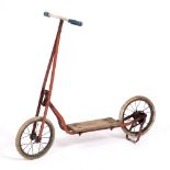 A 20TH CENTURY TRI-ANG CHILDREN'S SCOOTER with red painted decoration and mark to the wooden