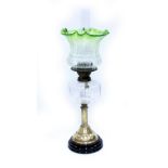 A LATE VICTORIAN OIL LAMP with clear glass reservoir and etched green tinted shade, robust mounts