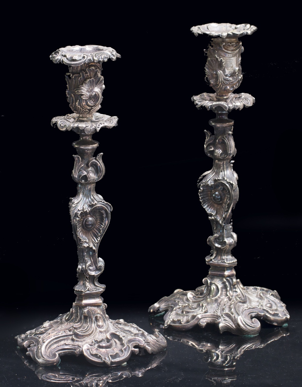A PAIR OF ANTIQUE SILVER PLATED ROCOCO STYLE CANDLESTICKS possibly by Elkington & Co., each engraved