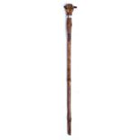 A FOLK ART WALKING STICK with fist handle and interesting carved decoration depicting animals,