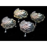 A SET OF FOUR GEORGE II SILVER SHELL SHAPED SALTS with tracing of gilding to the interior and each