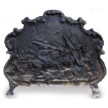 A CAST IRON FIRE BACK with shaped outline, cast with figures fighting on horseback, with scrolling