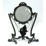 AN ART NOUVEAU STYLE WROUGHT METAL DECORATIVE MIRROR with a circular mirror plate above model of a