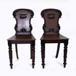 A PAIR OF 19TH CENTURY MAHOGANY HALL CHAIRS with scrolling acanthus backs, standing on ring turned