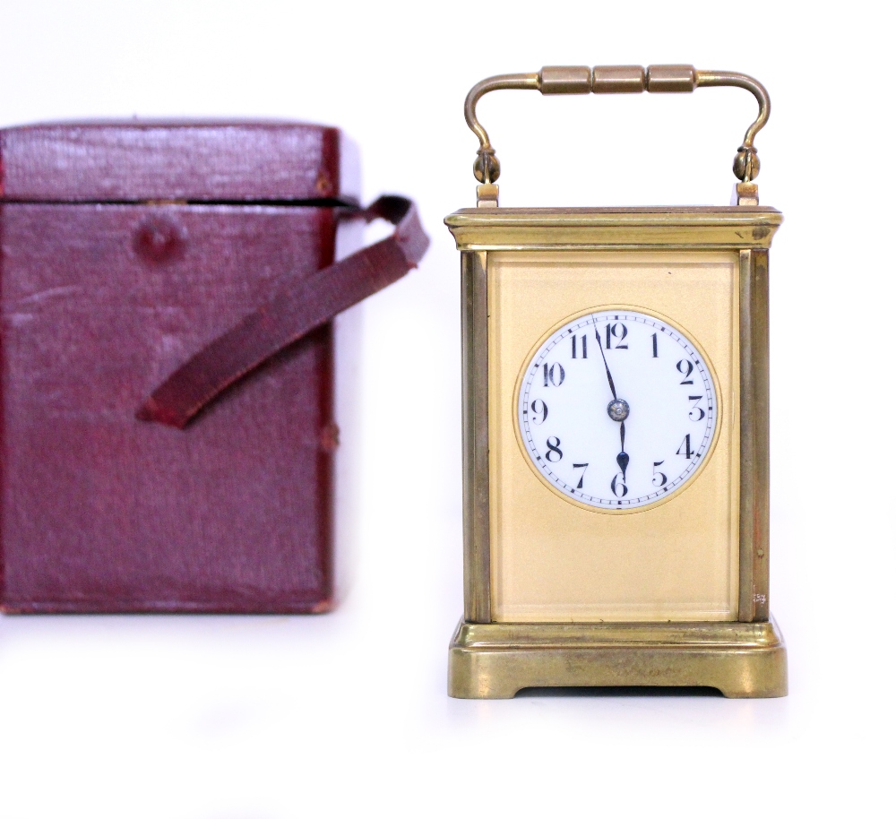 AN EARLY 20TH CENTURY BRASS CASED CARRIAGE CLOCK with white enamel dial and black Arabic numerals,