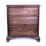 A 19TH CENTURY MAHOGANY CHEST OF THREE LONG DRAWERS with brass swan neck handles and raised on