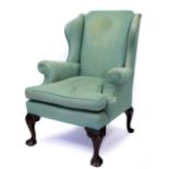 A GREEN UPHOLSTERED GEORGIAN STYLE WING BACK ARMCHAIR with claw and ball feet 73cm wide x 78cm