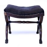 A 19TH CENTURY CONTINENTAL WALNUT X FRAMED STOOL with curving seat and carved paw feet, 49.5cm