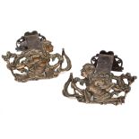 A PAIR OF CAST BRONZE CHENETS with moulded decoration of a figure holding a torch, 21cm x 26cm (a