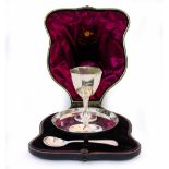 A SILVER EGG CUP AND STAND in a fitted case with marks for Birmingham 1922