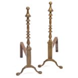 A PAIR OF 20TH CENTURY BRASS FIRE DOGS with finial, on knob stem standing on ball and claw feet,